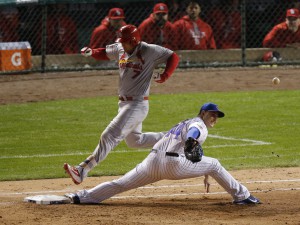 St. Louis Cardinals left fielder Matt Holliday (7) runs safely to the first base on a throwing error by Chicago Cubs second baseman Javier Baez (9) as first baseman Anthony Rizzo (44) can't misses the ball during the seventh inning of Game 3 in baseball's National League Division Series, Monday, Oct. 12, 2015, in Chicago. (AP Photo/Charles Rex Arbogast)