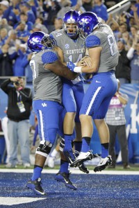 Kentucky quarterback Patrick Towles, center, celebrates his touchdown with teammates Kyle Meadows, left, and C.J. Conrad during the first half of an NCAA college football game against Missouri, Saturday, Sept. 26, 2015, in Lexington, Ky. (AP Photo/David Stephenson)