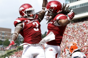 FILE - In this Sept. 5, 2015, file photo, Arkansas' Alex Collins (3) and Keon Hatcher (4) celebrate after Hatcher's touchdown during the NCAA college football game against UTEP at Donald W. Reynolds Razorback Stadium in Fayetteville, Ark. The Razorbacks beat the Miners, 48-13. (AP Photo/Samantha Baker, File)