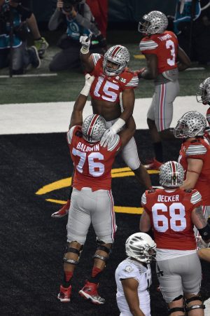 Jan 12, 2015; Arlington, TX, USA; Ohio State Buckeyes running back Ezekiel Elliott (15) and offensive lineman Darryl Baldwin (76) celebrate Elliot's touchdown against the Oregon Ducks during the game at AT&T Stadium. The Buckeyes defeated the Ducks 42-20. Mandatory Credit: Jerome Miron-USA TODAY Sports