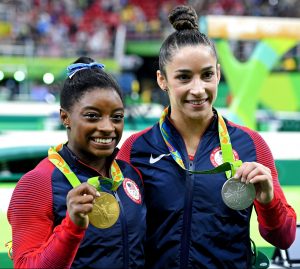 : Aug 11, 2016; Rio de Janeiro, Brazil; Simone Biles (USA) and Alexandra Raisman (USA) celebrate with their medals during the women's individual all-around final in the Rio 2016 Summer Olympic Games at Rio Olympic Arena. Mandatory Credit: Robert Hanashiro-USA TODAY Sports 
