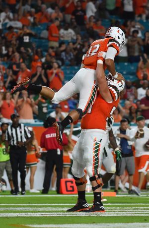 Sep 3, 2016; Miami Gardens, FL, USA; Miami Hurricanes offensive lineman Hunter Knighton (54) lifts quarterback Malik Rosier (12) to celebrate after his touchdown against the Florida A&M Rattlers during the second half at Hard Rock Stadium. The Miami Hurricanes defeat the Florida A&M Rattlers 70-3. Mandatory Credit: Jasen Vinlove-USA TODAY Sports