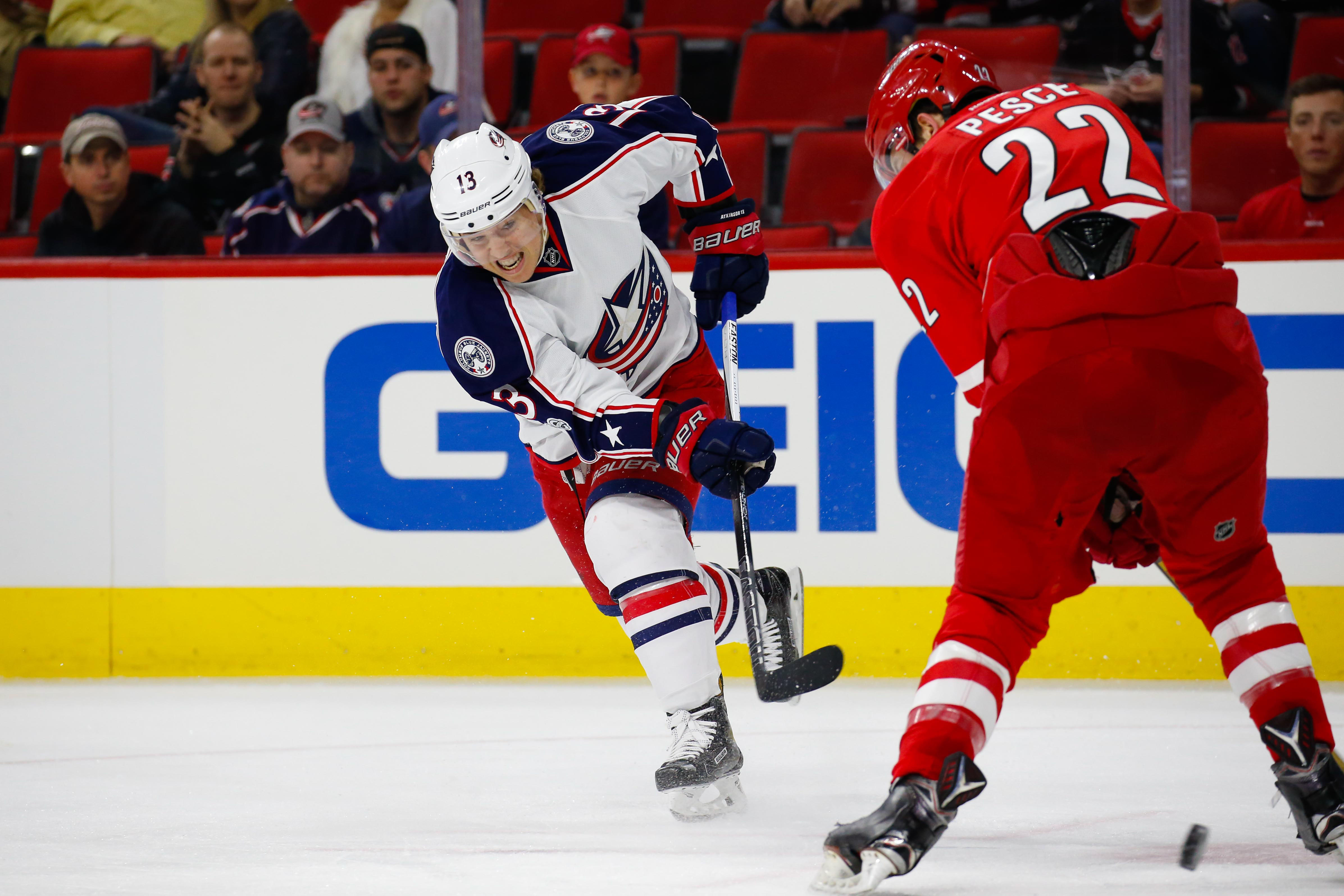 Jan 10, 2017; Raleigh, NC, USA; Columbus Blue Jackets forward Cam Atkinson (13) gets off the third period shot against Carolina Hurricanes defensemen Brett Pesce (22) at PNC Arena. The Carolina Hurricanes defeated the Columbus Blue Jackets 5-3. Mandatory Credit: James Guillory-USA TODAY Sports