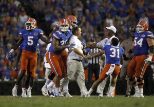 Sep 17, 2016; Gainesville, FL, USA; Florida Gators head coach Jim McElwain gets held back by tight end DeAndre Goolsby (30), defensive back Teez Tabor (31) and teammates during the second half at Ben Hill Griffin Stadium. Florida Gators defeated the North Texas Mean Green 32-0. Mandatory Credit: Kim Klement-USA TODAY Sports