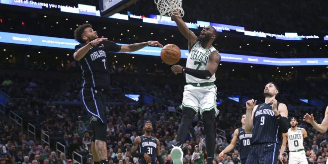 Magic players watch Celtics player dunk ball