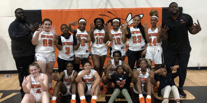 Girls basketball team poses after win