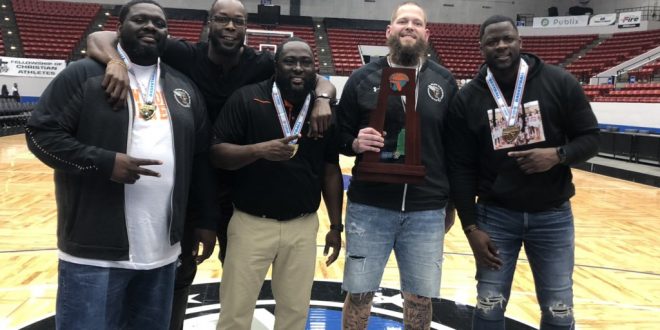 Hawthorne coaches pose with trophy