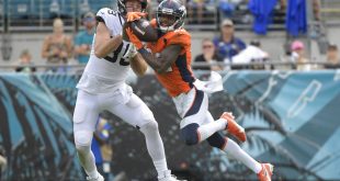 Jaguars fight Broncos for possession of the ball