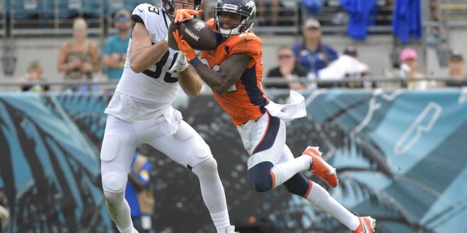 Jaguars fight Broncos for possession of the ball