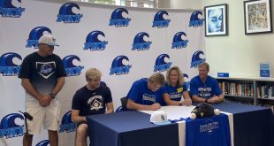 Drew Dawson signing his NLI with his coach and family.