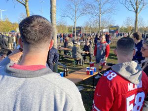 Fans gather outside of Allianz Arena participating in traditional tailgating games.