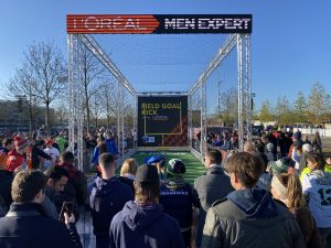 Fans gather around the "Field Goal Kick" challenge at the NFL Fan Experience outside of Allianz Arena.