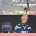 DJ Funshine smiles as she plays classic American music during the NFL Fan Fest in Munich, Germany. Among the many DJ booths and food vendors, the nearby 40-yard dash challenge entertained fans prior to the game.