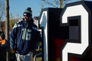 A smiling fan poses in front of the many photo opportunities provided at Allianz Arena for fans to enjoy. The number 12 is a significant number in the Seahawks fanbase because it was retired to honor the devotion of the fans in 1984.