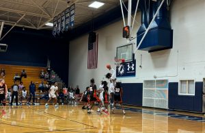 Santa Fe’s freshman point guard, Sylvester Lewis, shooting a layup over NFP defenders. [Liz Landen]