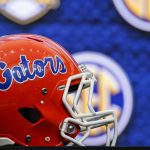 A Florida Gators helmet placed on the table in front of a screen showing the SEC logo.