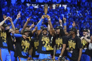 Oklahoma City Thunder guard Shai Gilgeous-Alexander, center, holds up the MVP trophy as he celebrates with his team after they won the NBA basketball championship with a Game 7 victory against the Indiana Pacers Sunday, June 22, 2025, in Oklahoma City. (AP Photo/Julio Cortez)