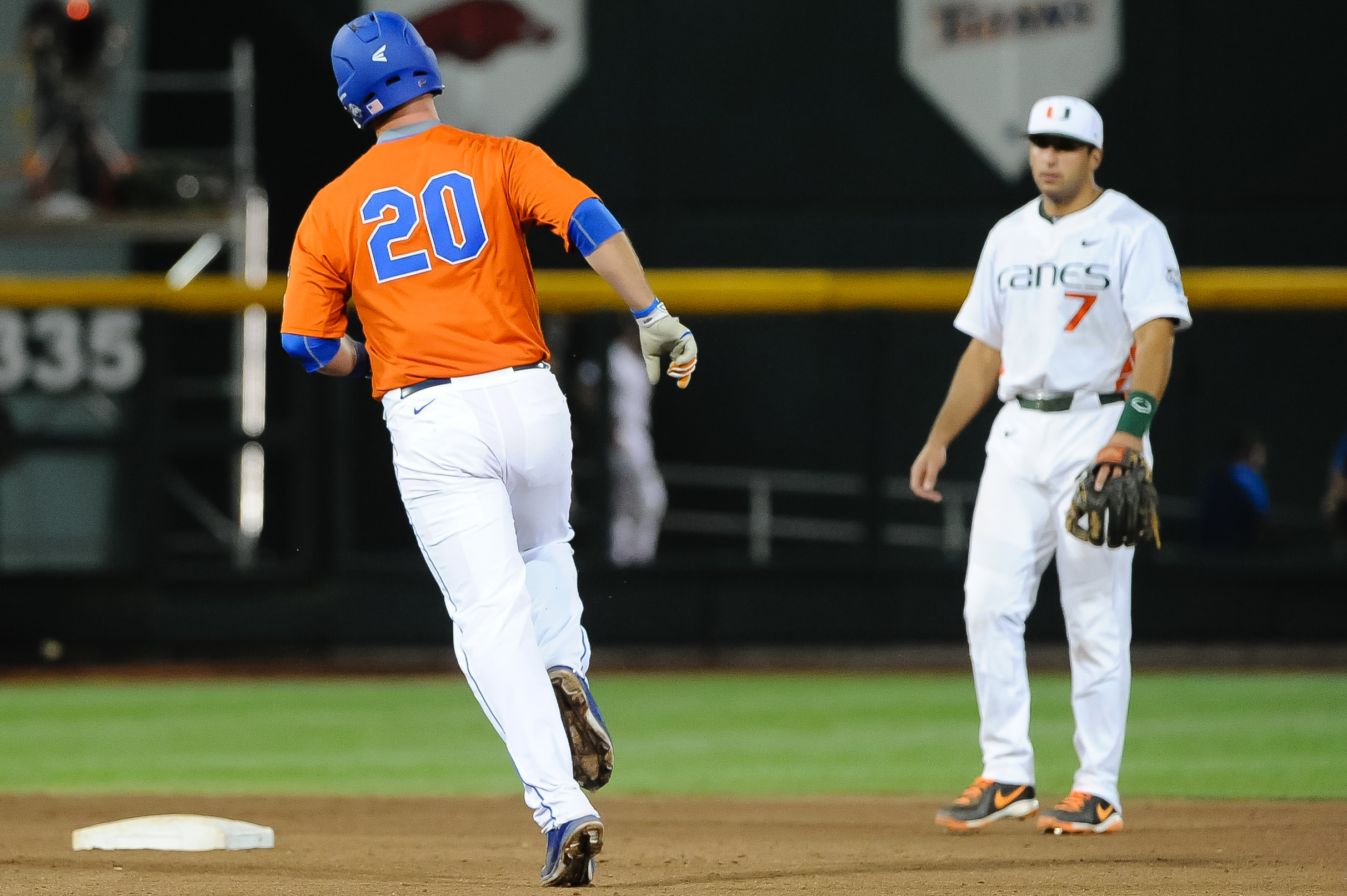 Jun 17, 2015; Omaha, NE, USA; Florida Gators infielder Peter Alonso (20) rounds second base after hitting a home run in the seventh inning as Miami Hurricanes infielder George Iskenderian (7) looks on in the 2015 College World Series at TD Ameritrade Park. The Gators won 10-2.