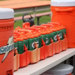 Gatorade sports drink coolers and bottles are lined up along the Mandarin High School bench during a high school football game against Creekside in Jacksonville, Florida, on September 23, 2022.