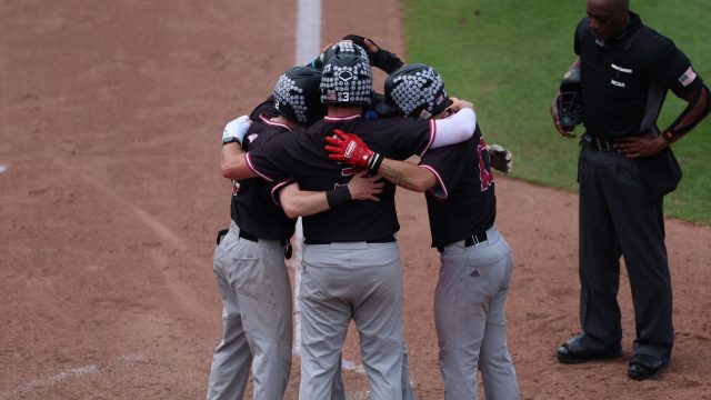 Anthony Paskell hugs his teammates at home plate after blasting a grand slam to tie the game in the top of the eighth. (Photo by Ryan Scarane/WRUF)