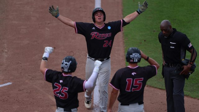 Nick Shuhett opens up for an embrace from his teammates at home plate after a two-run homer to take the lead in the eighth. (Photo by Ryan Scarane/WRUF)